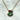 A gold chain necklace with a round bezel-set green gemstone pendant, displayed on a white marble surface.